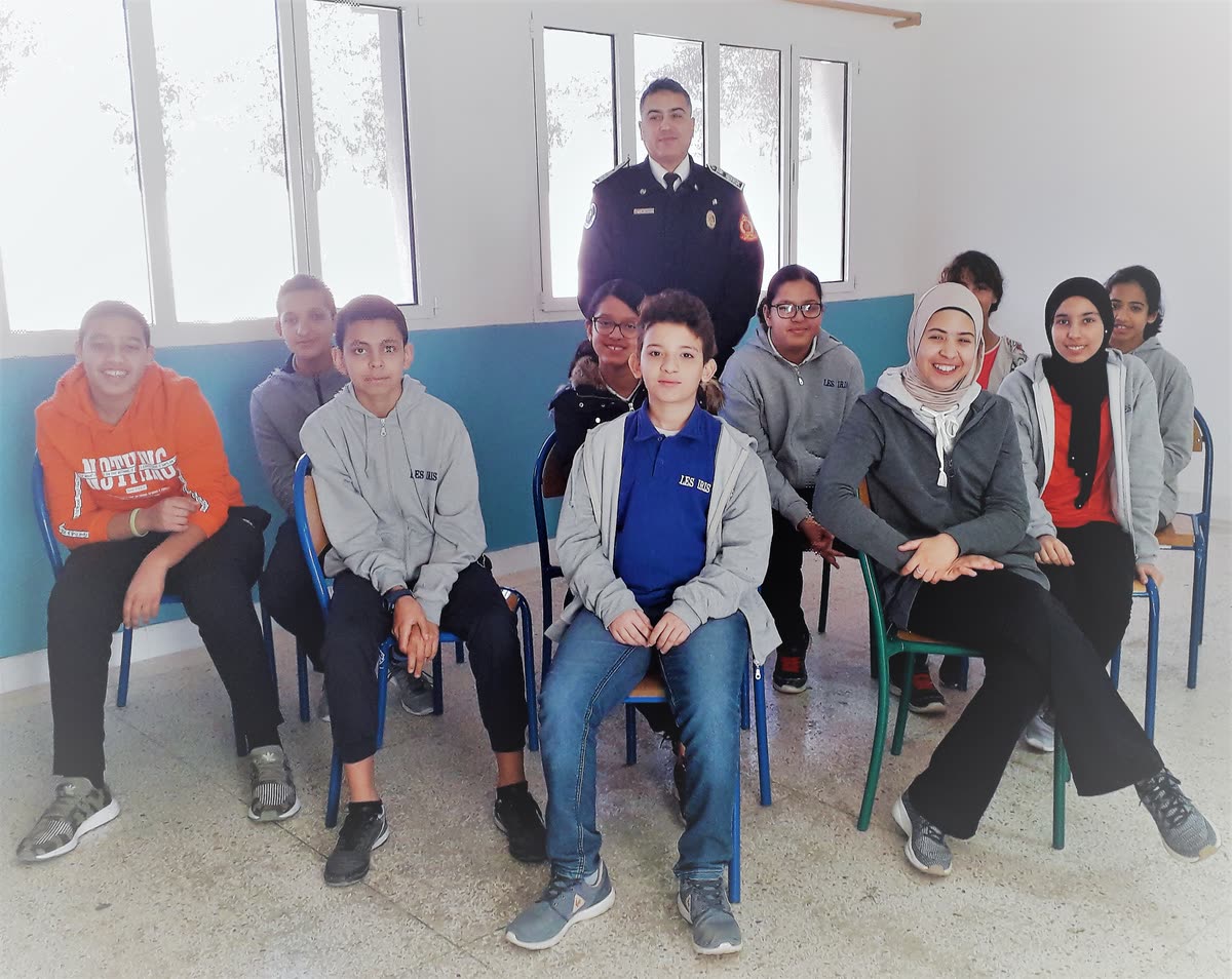 Groupe de collégiens de l’Institution Les Iris assis en classe autour d’un intervenant en uniforme lors d’une rencontre pédagogique